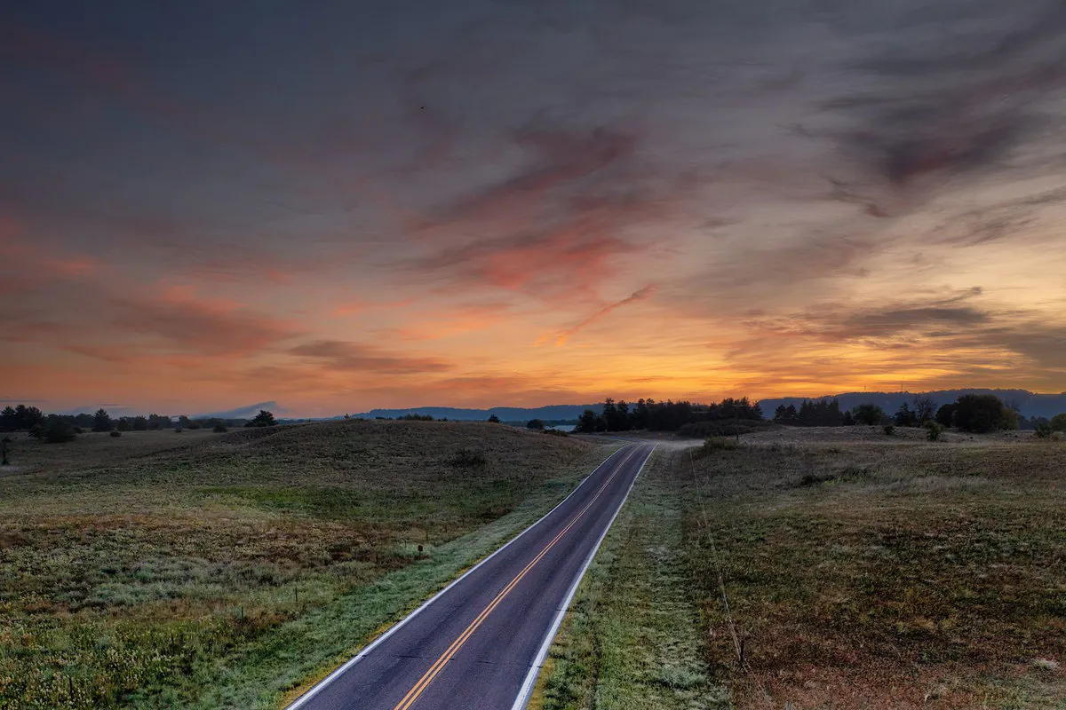Empty highway stretching toward the horizon at dusk